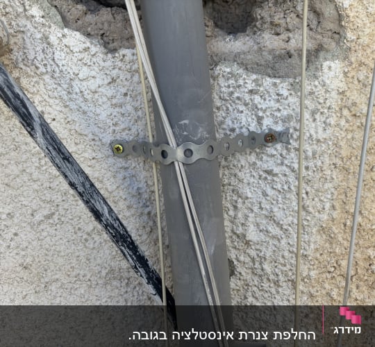 צינור מחובר לקיר עם תושבת מתכת וברגים